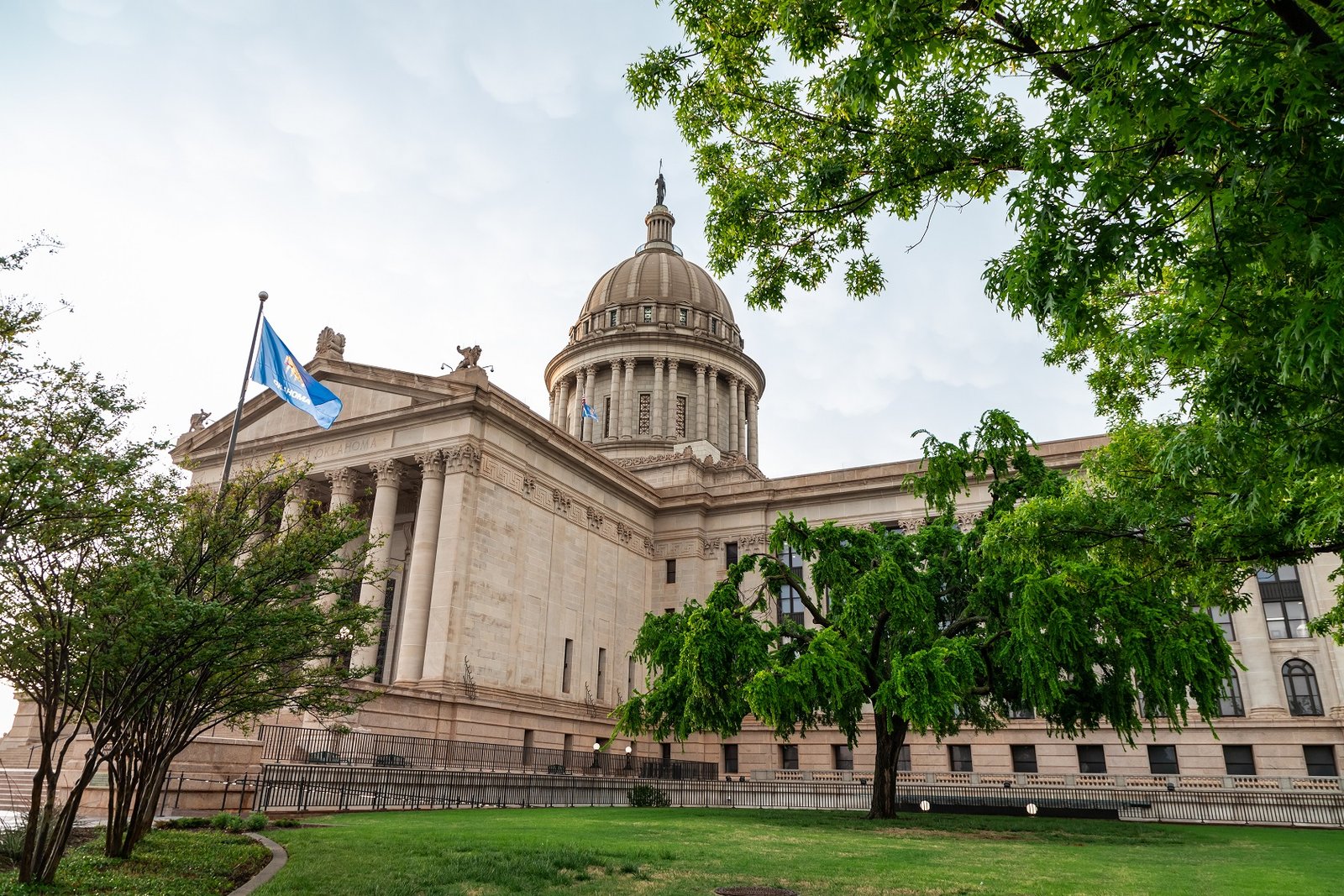 Oklahoma State Capitol framed by green trees